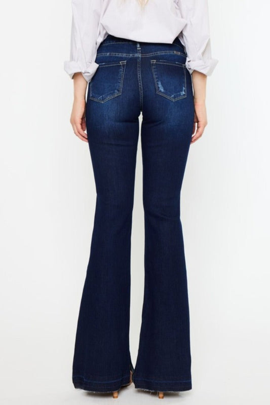 Stylish dark wash flare jeans styled casually with neutral heels.