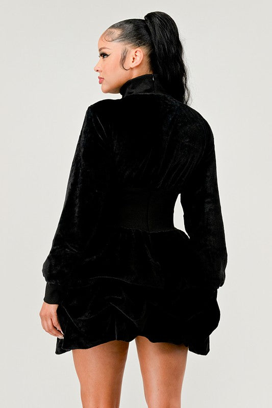 Black mock neck dress with a ruffled skirt for a whimsical silhouette.