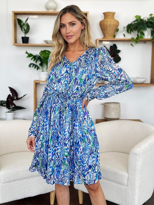 Lightweight blue dress featuring a flattering ruched design and vibrant tropical print.
