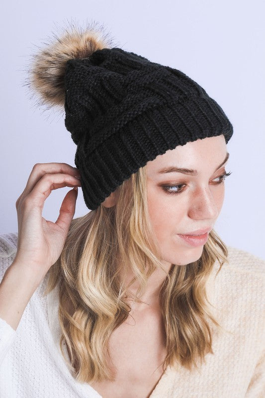 Classic black cable knit beanie with braided pattern and faux fur pom