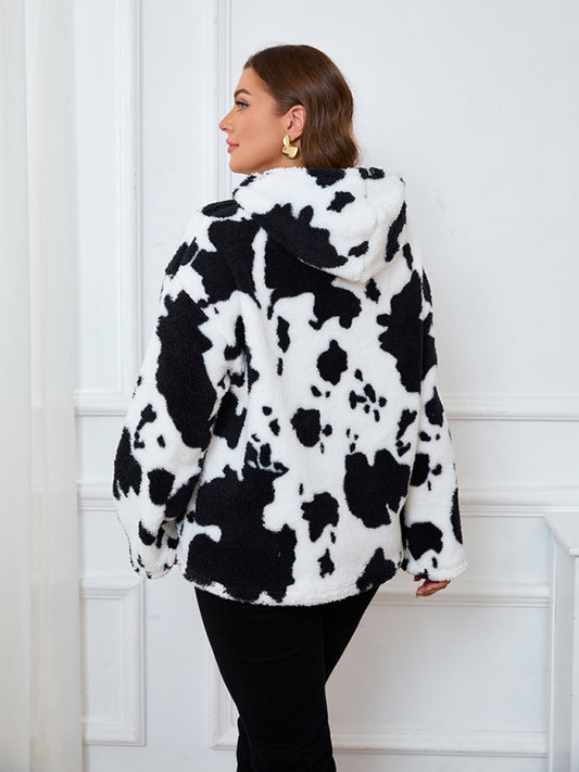 Cow print plush hoodie photographed in natural light for vibrant black and white contrast.