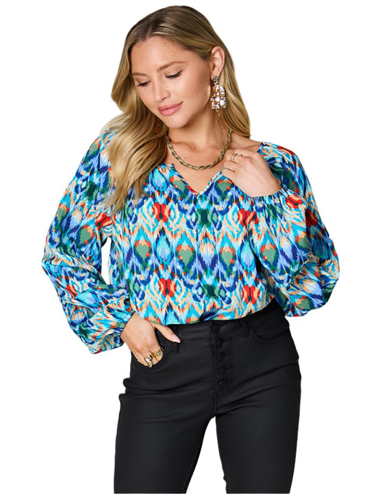 Sky blue Ikat print blouse with flowy long sleeves and V-neckline.