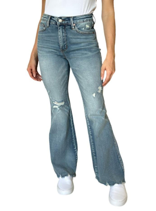 Front view of distressed flare jeans styled casually with sneakers.