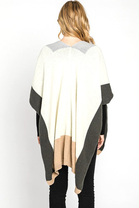 Woman layering with a cozy, oversized color-blocked poncho.