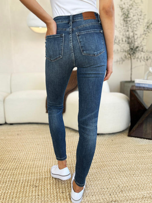 Women’s mid-waist jeans with subtle ripped details.