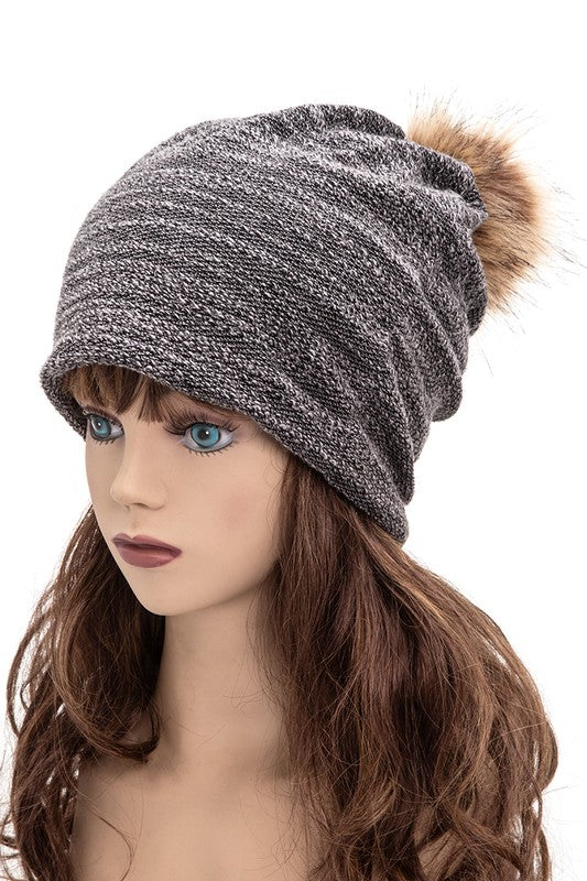 Comfortable black slouchy beanie featuring snap-on fur pom