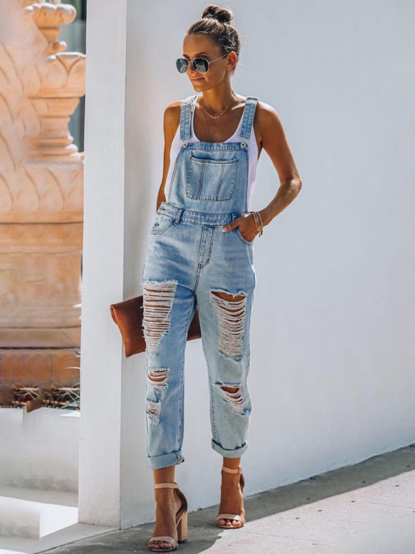 Full-body view of women’s relaxed fit ripped overalls paired with summer heels.