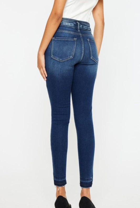 Back view of stylish high-rise skinny jeans with raw hem by Kancan.