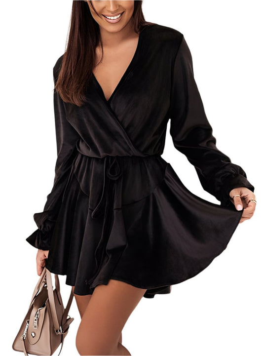 Woman in black velvet tie-waist dress with V-neck and ruffle cuffs.