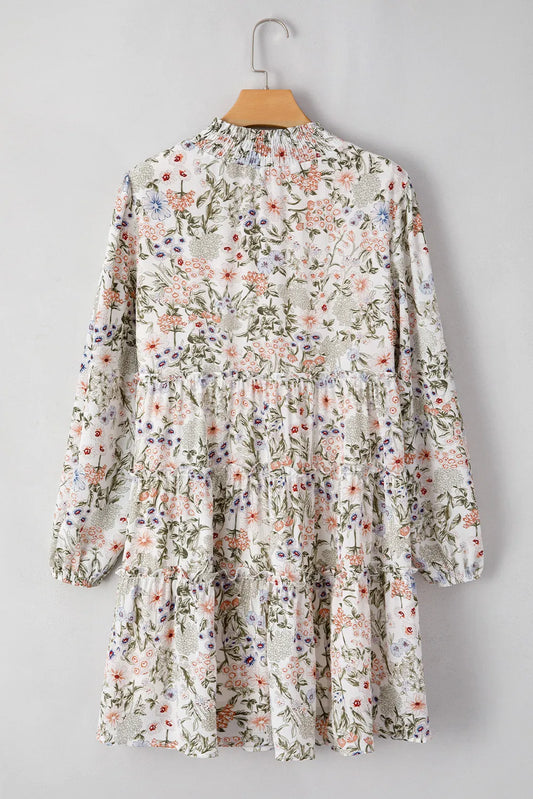Trendy tiered smock dress with balloon sleeves and delicate floral prints.