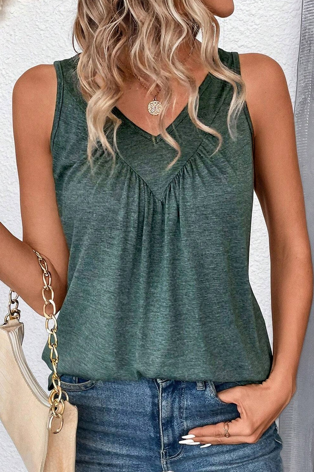 Elegant green sleeveless V-neck top with pleated front