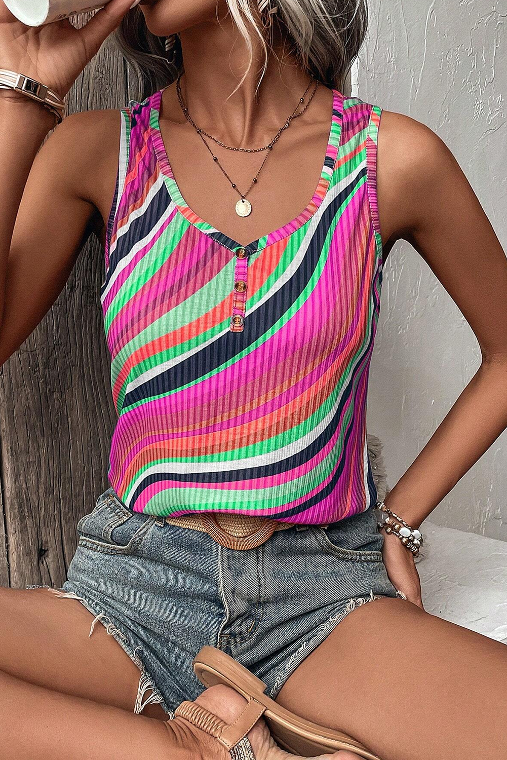 Playful sleeveless top with multicolor stripes and button accents.