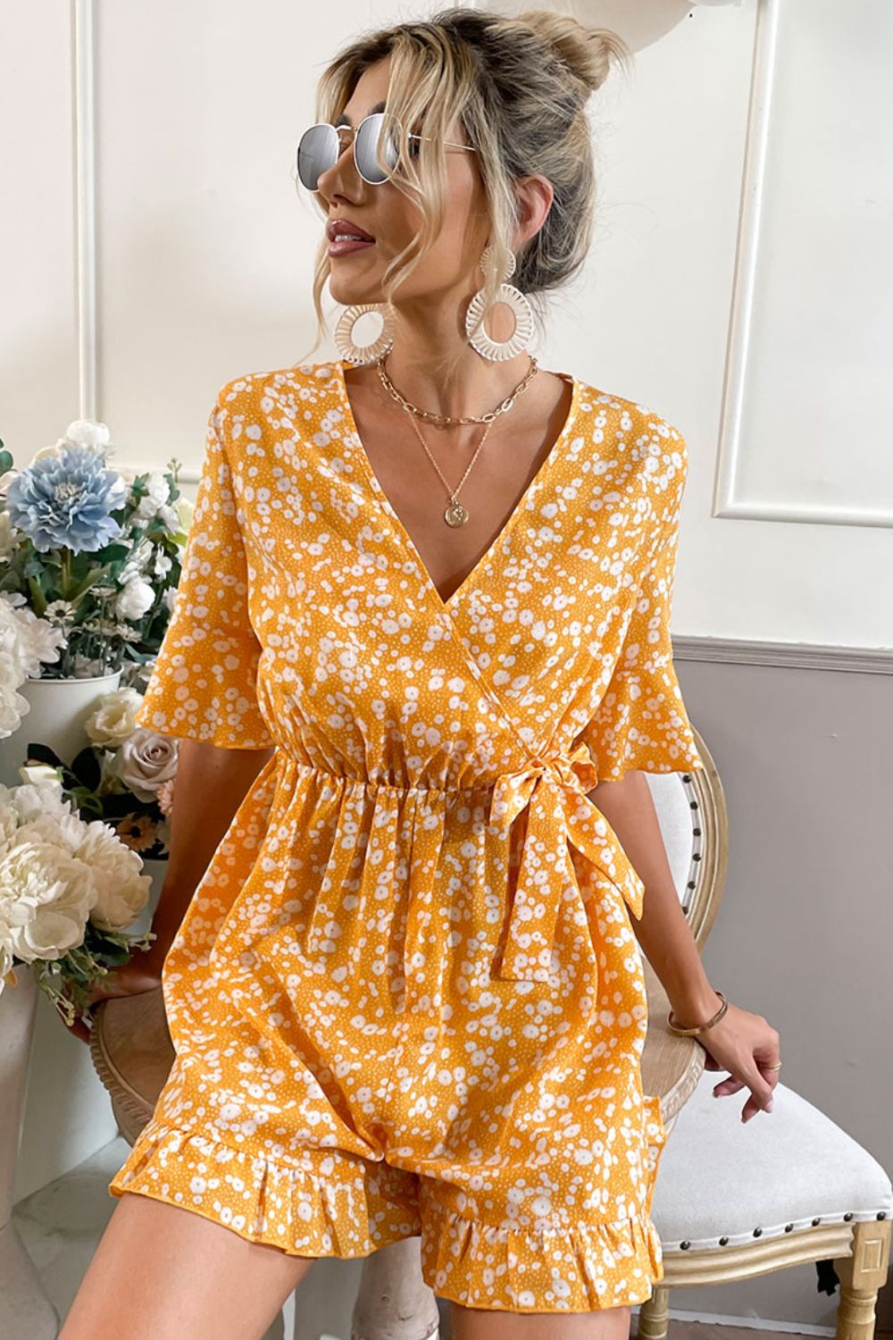 Embrace summer vibes with this chic marigold romper featuring a surplice neckline, ruffled hem, and a comfy elastic waist. Perfect for any outing