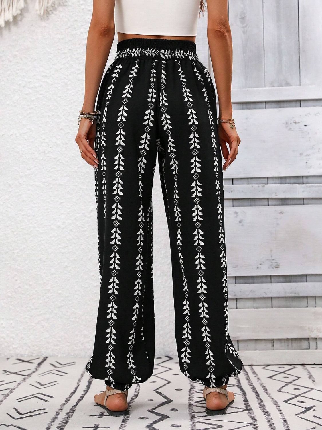 Black drawstring pants featuring a stylish bohemian print