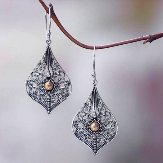 Teardrop earrings featuring a detailed filigree pattern and a central pearl bead