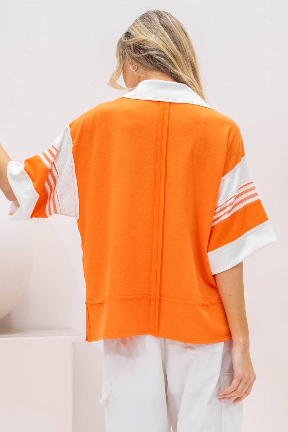 Orange pullover featuring bold white stripe accents