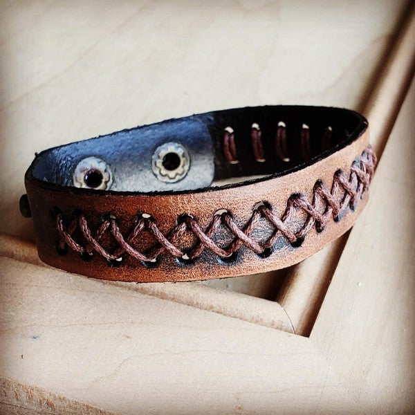 Handcrafted leather bracelet with brown thread detailing and snap closure