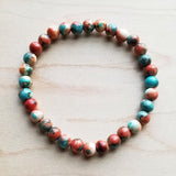 Multicolor bead bracelet with vibrant red, teal, and cream hues
