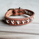 Handcrafted leather bracelet with white thread detailing and brass buckle