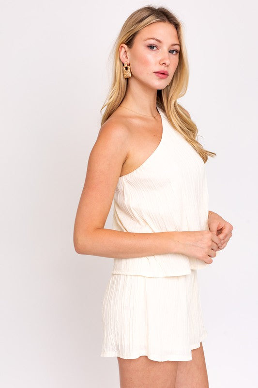 Lightweight cream one-shoulder top and shorts, perfect for relaxed, stylish looks.