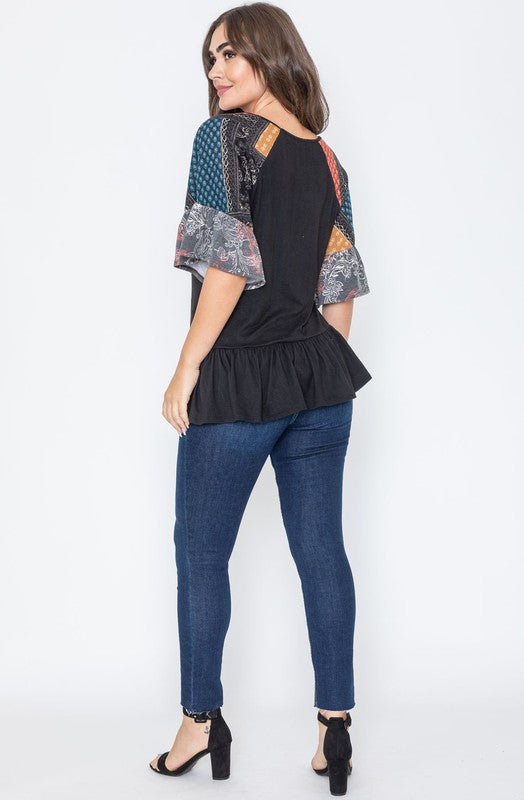 Black peplum top with eye-catching patchwork on sleeves