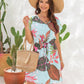 Summer-chic V-neck mini dress with a tropical print and adjustable drawstring waist for a comfy, stylish fit perfect for sunny days.