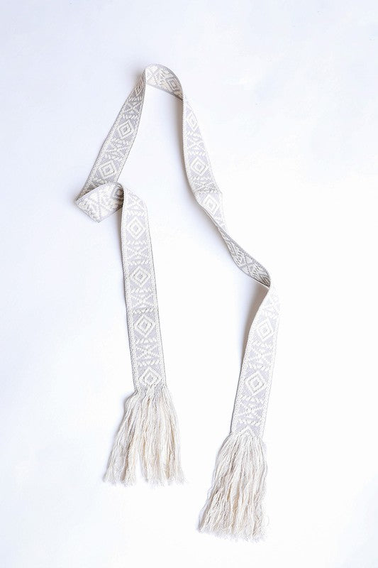 Intricate beige fabric belt with geometric patterns and tassels