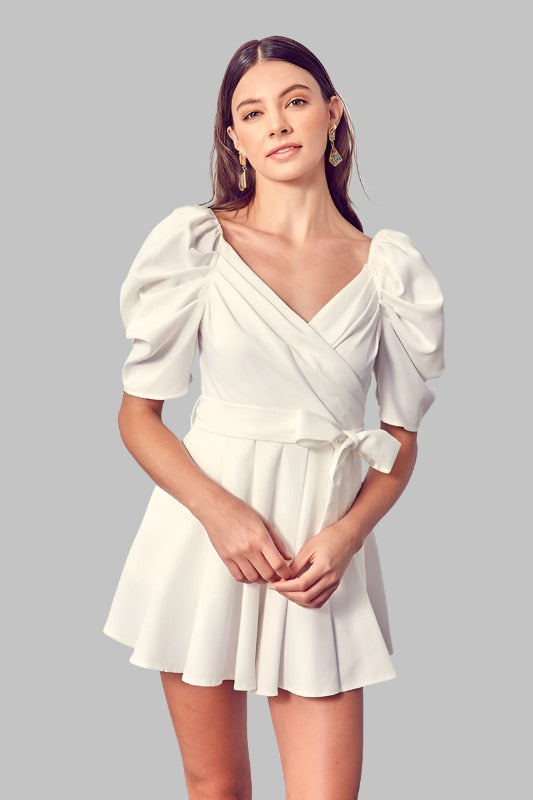 White romper with wrap front and side tie, featuring puffed sleeves.