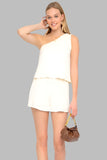 Cream one-shoulder top and shorts set featuring lightweight, breathable fabric.