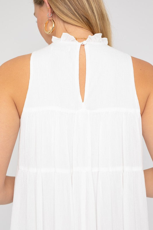 Close-up of the ruffle detail on the high-neck white dress.