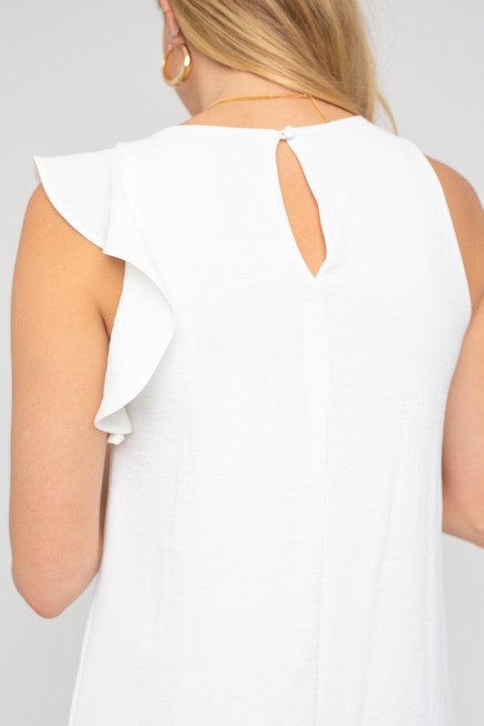 Close-up of the ruffle shoulder detail on a white dress.