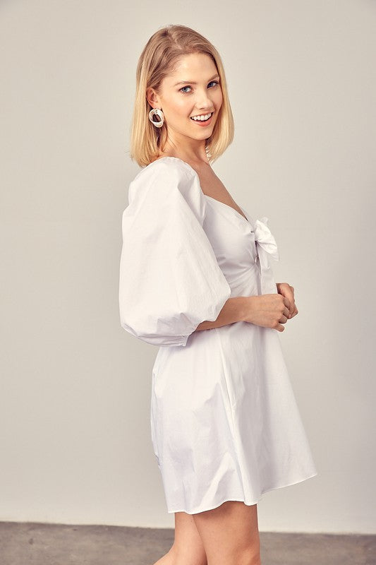 Mini dress in white with side pockets and puff sleeves.