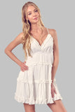 White mini dress featuring ruffled tiers and V-neck design