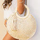 Woven straw tote bag with round handles and tassel accents.