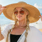 Stylish straw hat with wide brim and bow, ideal for summer outings.
