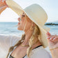 Sunhat with wide brim and bow, perfect accessory for beach vacations.