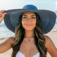 Elegant wide brim straw hat with bow detail, perfect for sun protection.