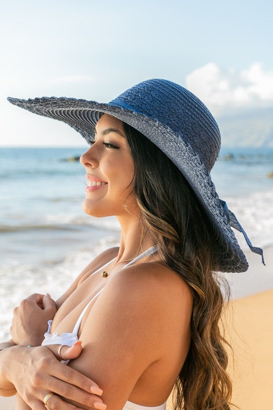 Stylish straw hat with wide brim and bow, ideal for summer outings.