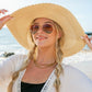 Wide brim straw hat with bow, offering chic sun protection for women.