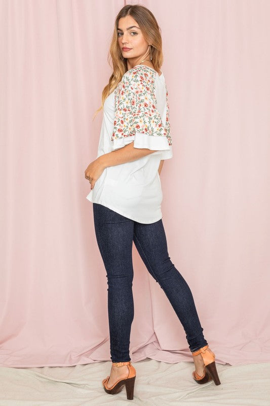 Plus size white tee with floral ruffle sleeve design.