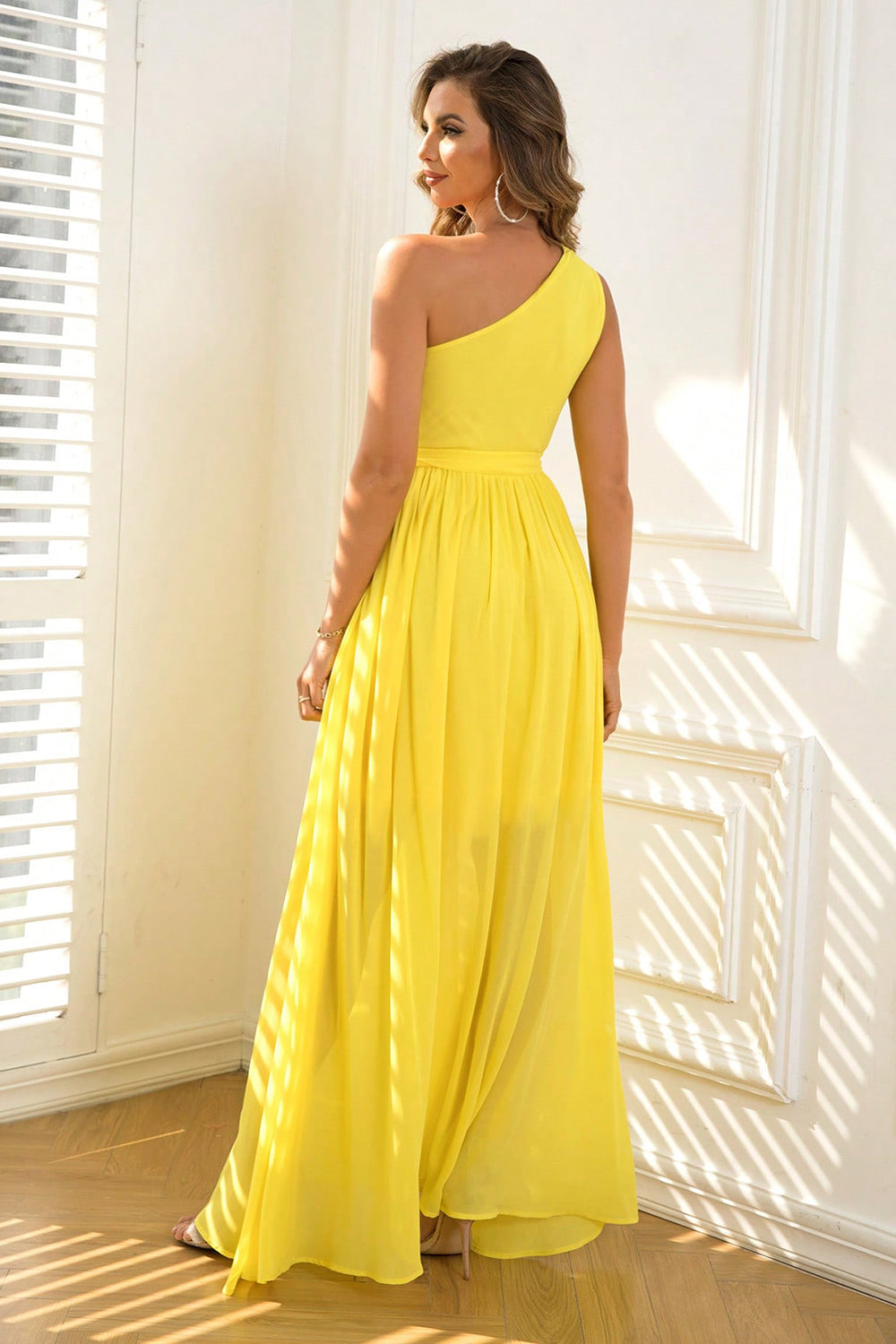 Bright yellow dress with an asymmetric neckline and a long, airy skirt