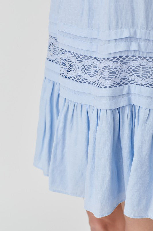 Flattering blue halter dress with flowy fit and lace accents.