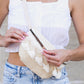 Zip closure sling bag featuring macrame tassels and adjustable vegan leather strap