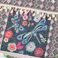 Close-up of beaded dragonfly and floral patterns on a black and white geometric tote bag