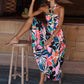 Vibrant floral print halter maxi dress with a tie neck and flowy silhouette.