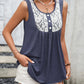 Women's navy sleeveless top with lace trim and buttons.