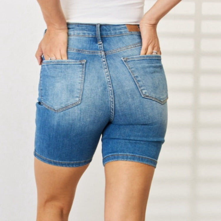 Elevate your summer wardrobe with Judy Blue's Double Button Bermuda Denim Shorts, offering tummy control for a sleek look and ultimate comfort.