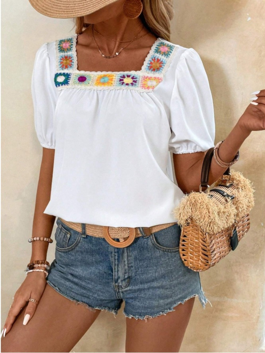 white blouse with short puff sleeves and a colorful crochet square neckline, featuring a relaxed fit perfect for a casual summer look