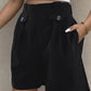 Chic black shorts with decorative buttons and pockets, perfect for versatile summer style and comfort.