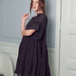 Elegant black tiered dress with a V-neckline and ruffled accents.